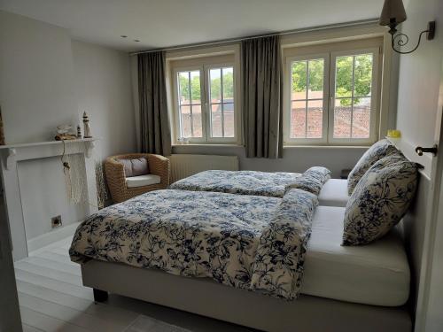 1 dormitorio con 1 cama, 1 silla y ventanas en Maison Rose en Ypres