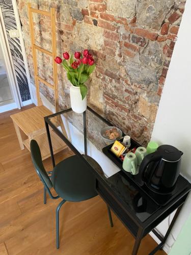 szklany stół z wazą z czerwonymi kwiatami w obiekcie La Matilde w Viareggio
