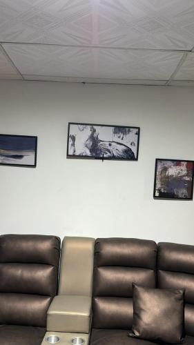 a leather couch in a room with pictures on the wall at La plata huila in La Plata