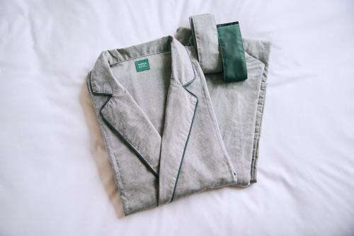 a gray jacket with a green bow tie on a bed at NOHGA HOTEL AKIHABARA TOKYO in Tokyo