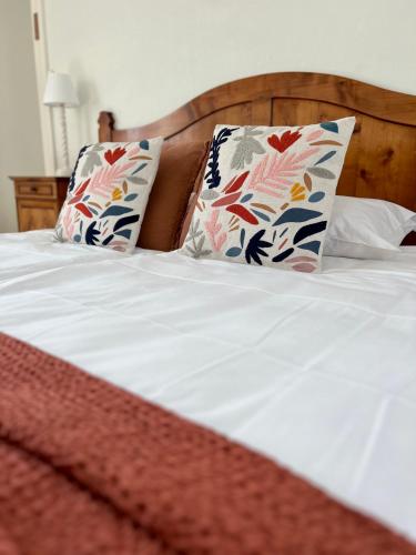 un lit blanc avec deux oreillers dessus dans l'établissement L'Isly, Dernier étage en centre de Rennes avec terrasse de 50m2, à Rennes