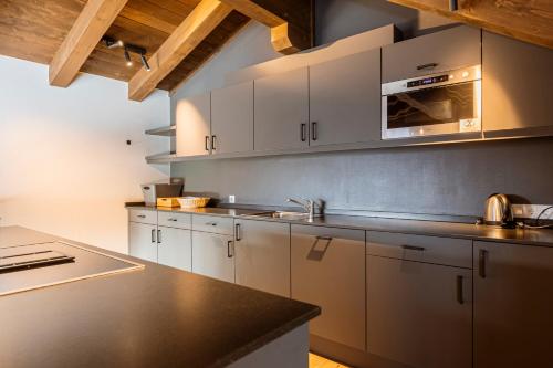 a kitchen with white cabinets and a black counter top at Bergresort Zugspitze Ehrwald by ALPS RESORTS in Ehrwald