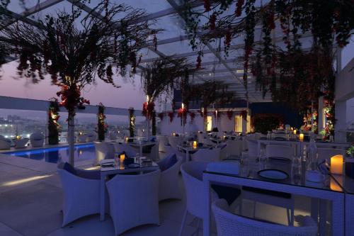 a restaurant with white tables and chairs at night at Hilton Garden Inn Pune Hinjawadi in Pune