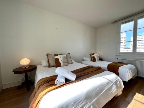 a bedroom with two beds and a window at L'Isly, Dernier étage en centre de Rennes avec terrasse de 50m2 in Rennes