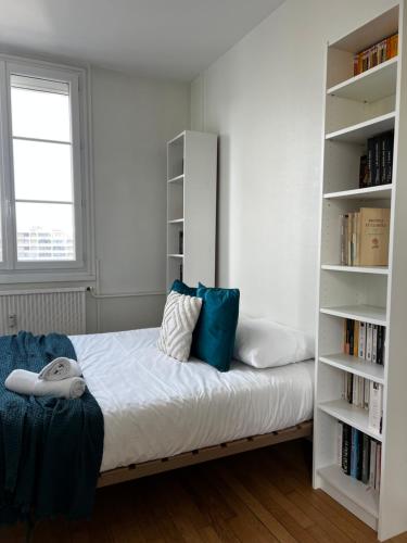 a bedroom with a bed with a book shelf at L'Isly, Dernier étage en centre de Rennes avec terrasse de 50m2 in Rennes