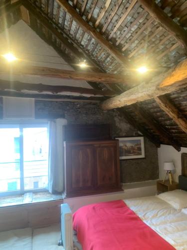 a bedroom with a large bed and a window at Maison de village de 1802, fraîchement rénovée à Beauvezer 04370 in Beauvezer