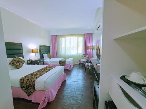 a hotel room with two beds and a living room at Fiesta Garden Hotel by SMS Hospitality in Vigan