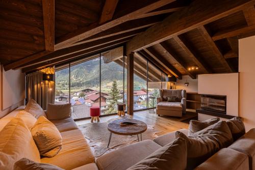 a living room with a large couch and a table at Bergresort Zugspitze Ehrwald by ALPS RESORTS in Ehrwald