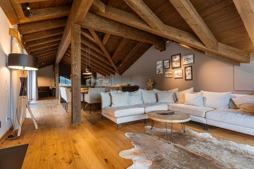 a living room with a white couch and a table at Bergresort Zugspitze Ehrwald by ALPS RESORTS in Ehrwald