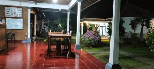 a house with a table and chairs on a patio at Bayumantra Bungalows in Lovina