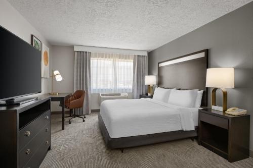 a hotel room with a bed and a television at Holiday Inn & Suites Albuquerque Airport by IHG in Albuquerque