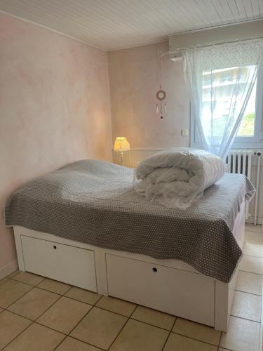un petit lit dans une chambre avec une fenêtre dans l'établissement Appartement 32m2 , quartier du Vieil Alpe, à Huez