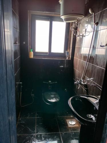 a bathroom with a sink and a toilet and a window at Villa Mostafa Sadek, Swimming pool, Tennis & Squash - Borg ElArab Airport Alexandria in Borg El Arab