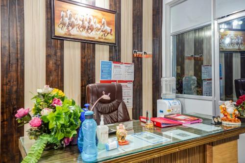 un salón con una barra de cristal con una silla y flores en Hotel Welcome Sri Vip Road Raipur en Phundardih
