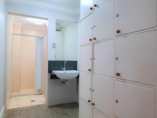 a bathroom with white cabinets and a sink at Fiesta Garden Hotel in Vigan