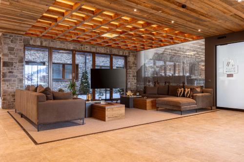 a living room with couches and a flat screen tv at Bergresort Zugspitze Ehrwald by ALPS RESORTS in Ehrwald