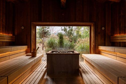 an empty sauna with a large window and a hot tub at Bergresort Zugspitze Ehrwald by ALPS RESORTS in Ehrwald