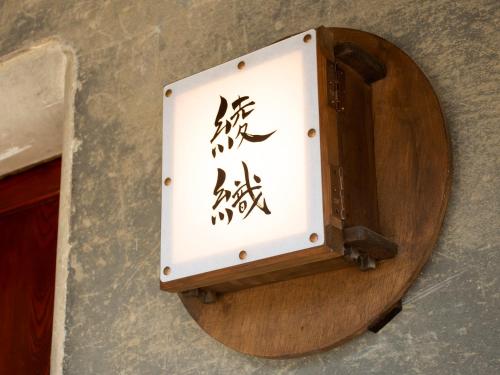 eine Kiste mit einer Aufschrift an einer Wand in der Unterkunft がもう家 明治時代の蔵に泊まれる一棟貸し宿 Ancient renovated house in the Japanese Countryside with a kindly hospitality in Sakaide