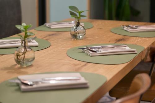 a wooden table with four plates and vases on it at Avenue Boutique Hotel in Como