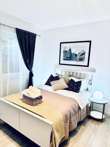 a white bedroom with a large bed and a window at Bri Central Apartment in Deva