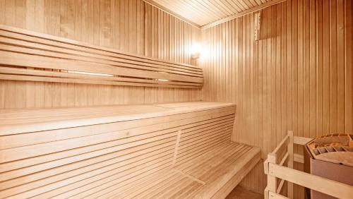 a wooden sauna with a wooden bench in it at Hotel Les Tourelles in Sainte-Maxime