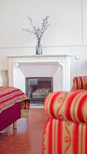a living room with two couches and a fireplace at Hotel Les Tourelles in Sainte-Maxime