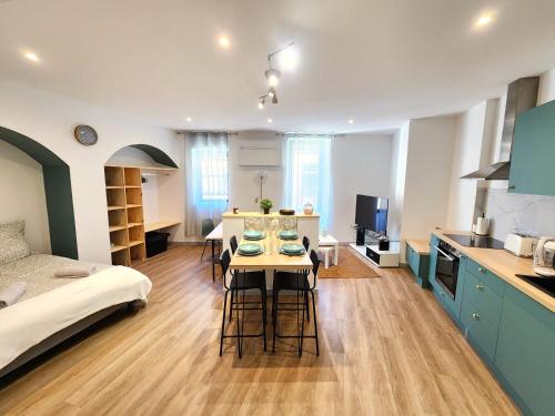 a kitchen and living room with a table and chairs at Arches Florales de Marmande in Marmande