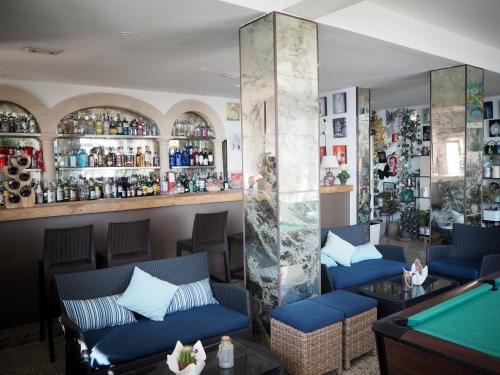 un bar con sofás azules y una mesa de billar en Hotel Rocamar en Cala Figuera