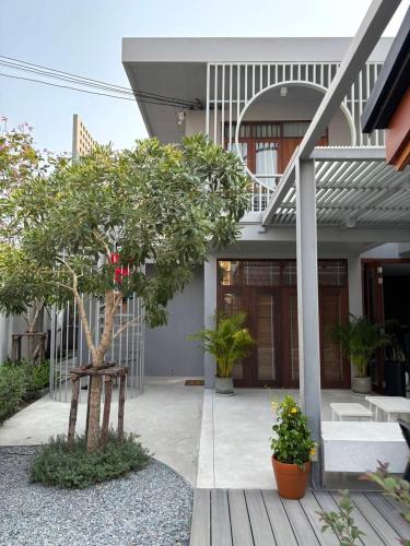 a house with a tree in the front yard at ROOMS at Number60 Khaosan Bangkok in Bangkok