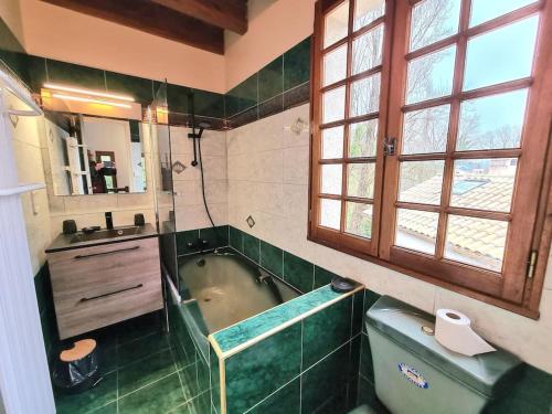 une salle de bain avec une baignoire et un lavabo dans l'établissement Domaine du Moulin de Candresse, à Candresse