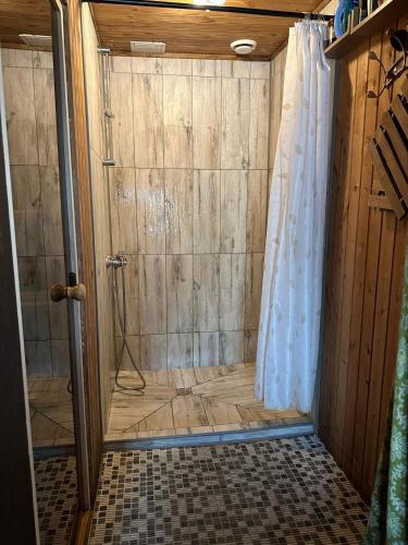 a shower with a shower curtain in a bathroom at Rama House in Liepāja