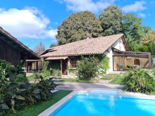 une maison avec une piscine devant dans l'établissement Domaine du Moulin de Candresse, à Candresse