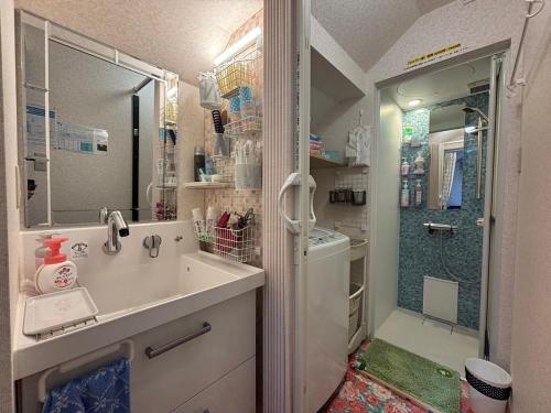 a bathroom with a sink and a shower at Guest House モモ in Obihiro