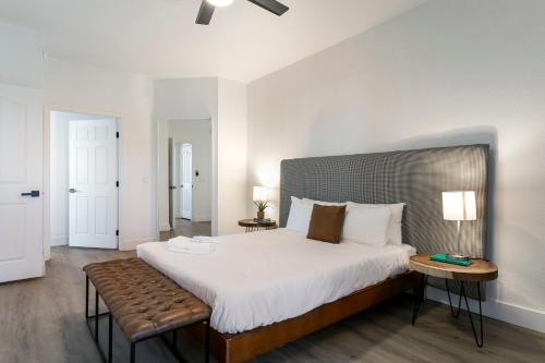 Schlafzimmer mit einem großen Bett mit einer Bank in der Unterkunft 2BR CozySuites at Kierland Commons with pool #01 in Scottsdale