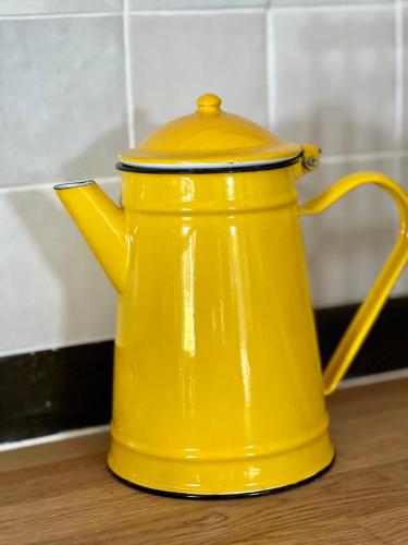 une bouilloire jaune posée sur une table dans l'établissement La Maison Bucolique, Centre de Saint Jacques, à Saint-Jacques-de-la-Lande