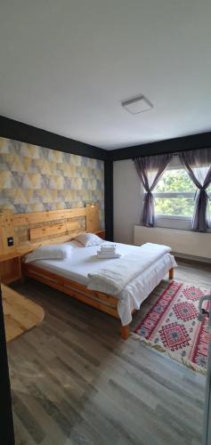 a bedroom with a large bed and a window at Casa David in Buşteni
