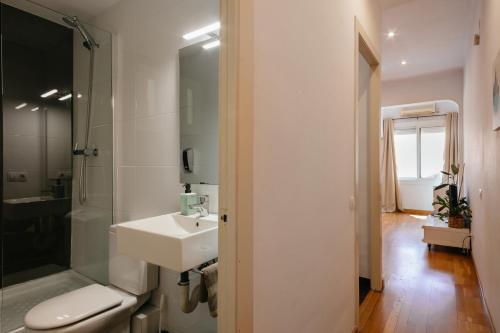 een badkamer met een wastafel, een douche en een toilet bij Cute Apartment in Barcelona