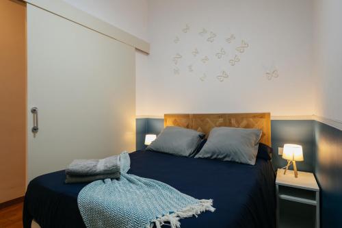 een slaapkamer met een blauw bed en een blauwe deken bij Cute Apartment in Barcelona