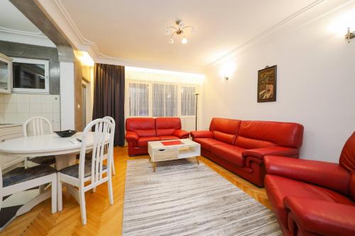 salon z czerwoną kanapą i stołem w obiekcie Apartament Erisa w mieście Peć