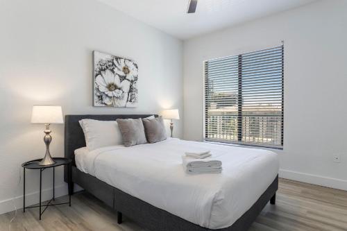 - une chambre blanche avec un grand lit et une fenêtre dans l'établissement 3BR CozySuites at Kierland Commons with pool #12, à Scottsdale