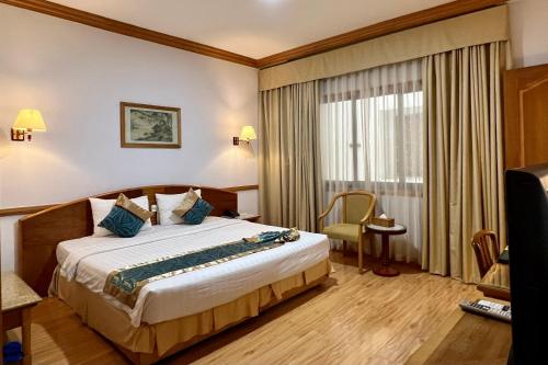 a hotel room with a bed and a window at Oscar Saigon Hotel in Ho Chi Minh City