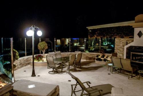 a patio with a table and chairs at night at La Mansión Residency Suites Ensenada in Ensenada