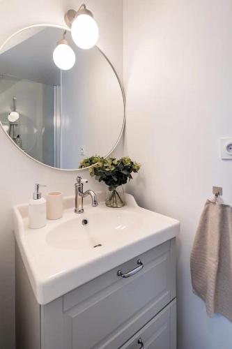 une salle de bain avec un lavabo blanc et un miroir dans l'établissement Chaleureuse maisonnette, à Montreuil-Bellay