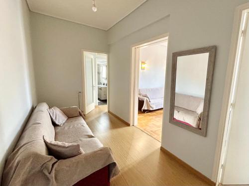 een woonkamer met een bank en een spiegel bij Bella Vista Apartment in Chios