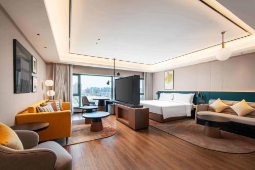 a hotel room with a bed and a television at Hilton Garden Inn Beijing West Railway Station in Beijing