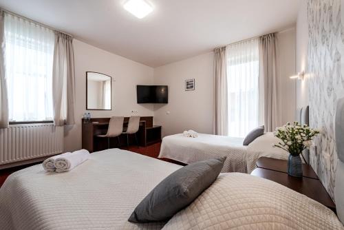 Pokój z 3 łóżkami i biurkiem w obiekcie Hotel "Na Uboczu" w Warszawie