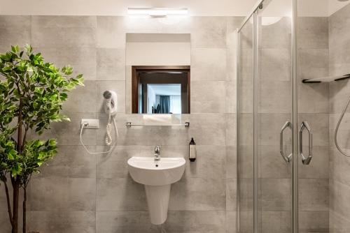 a bathroom with a sink and a shower at Hotel "Na Uboczu" in Warsaw