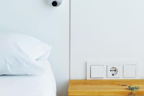 a bedroom with a bed and an alarm clock on a nightstand at Typic Marina Playa - Adults Only in San Antonio Bay