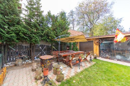 a backyard with a picnic table and an umbrella at Casa Nan cu Terasa - Castelul Bran in Bran