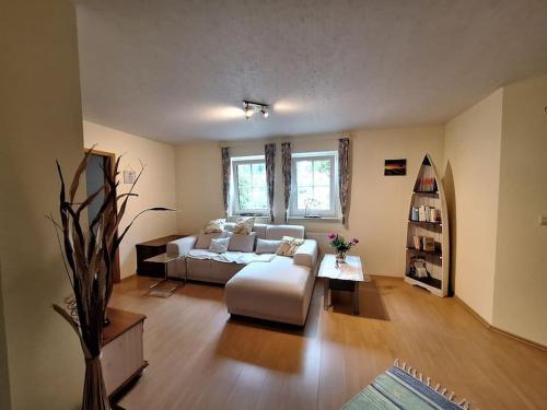 a living room with a couch and a table at Gemütliche Ferienwohnung mit Kupfertalblick in Forchtenberg